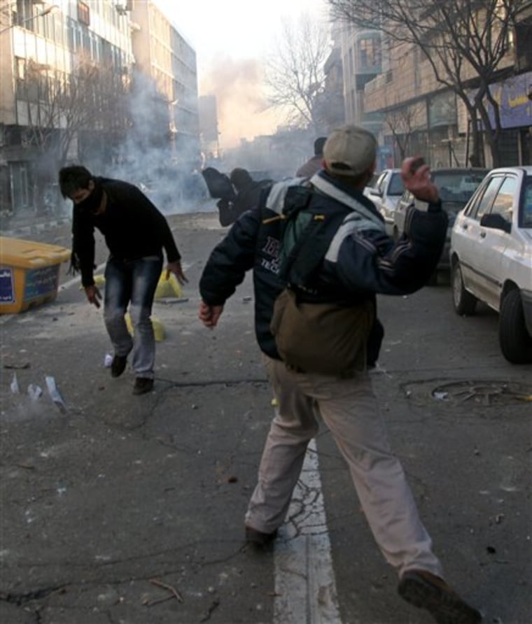 This photo, taken by an individual not employed by the Associated Press and obtained by the AP outside Iran, shows Iranian protesters throwing stones at anti-riot police Monday during an anti-government protest in Tehran, Iran.